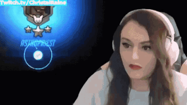 a woman wearing pink headphones is sitting in front of a screen that says ' twitch.tv / christa '