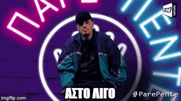a man in a blue jacket is standing in front of a neon sign that says ' parepente '