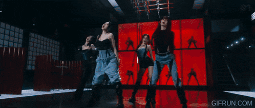 a woman in a black dress is dancing in the dark