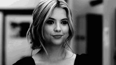 a black and white photo of a woman with blonde hair smiling .