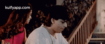 a man and a woman are standing next to each other on stairs .