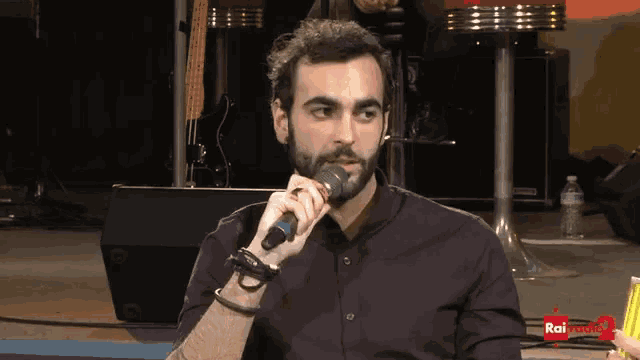 a man is holding a microphone in front of rai radio