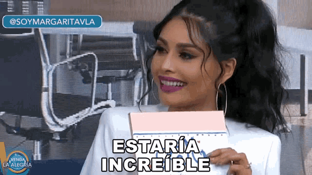 a woman is smiling and holding a notebook that says estaria increible on it