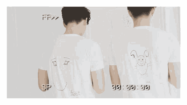 two men are standing next to each other wearing white t-shirts with a drawing of a face on the back ..