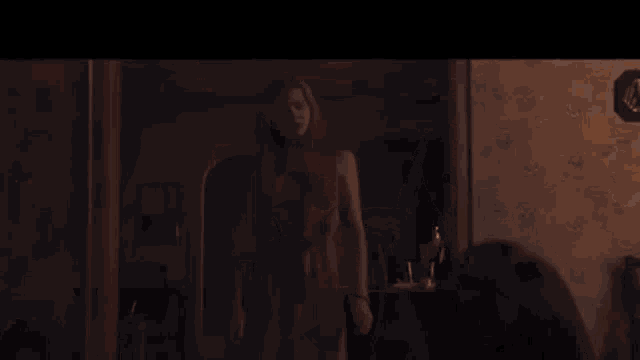 a woman is standing in front of a lamp in a room .