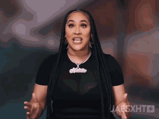 a woman with braids is wearing a black shirt and a necklace with the name malika on it .