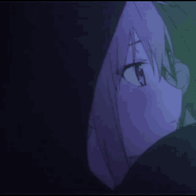 a close up of a person 's face in a dark room with purple hair .