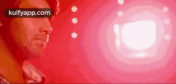 a man in a red shirt is standing in front of a red background .