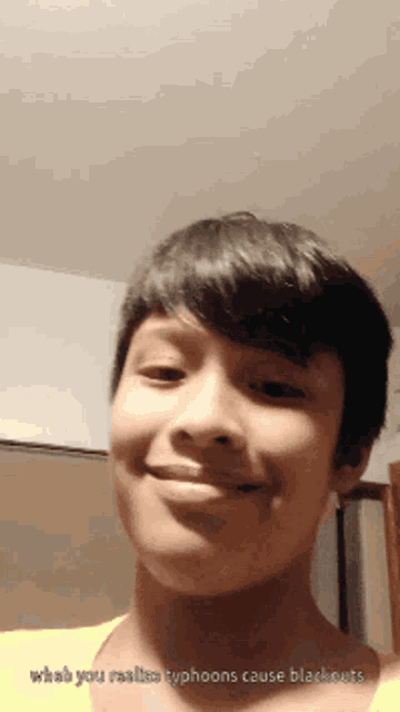 a young boy smiles with the words " what you realize typhoons cause blackouts " next to him