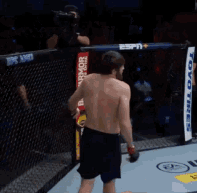a shirtless man in a boxing ring with a toyo banner in the background