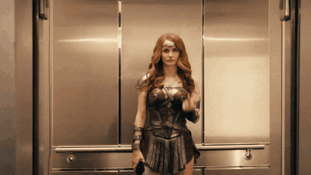 a woman in a superhero costume stands in an elevator