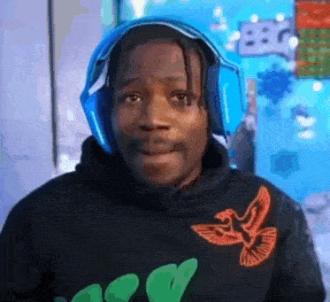 a man wearing headphones and a black hoodie is looking at the camera .