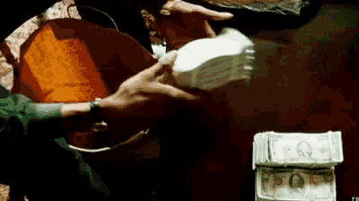 a person handing another person a stack of money