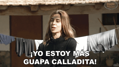 a woman says yo estoy mas guapa calladita in front of a clothesline