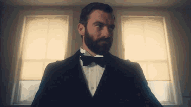 a man with a beard wearing a tuxedo with a bow tie