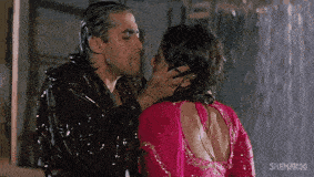 a man and woman are kissing in the rain in a movie .
