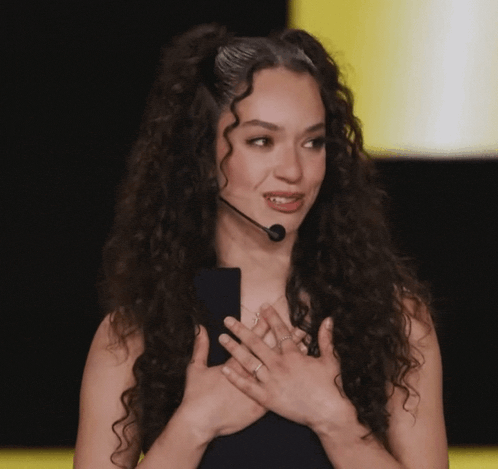 a woman with curly hair is wearing a headset