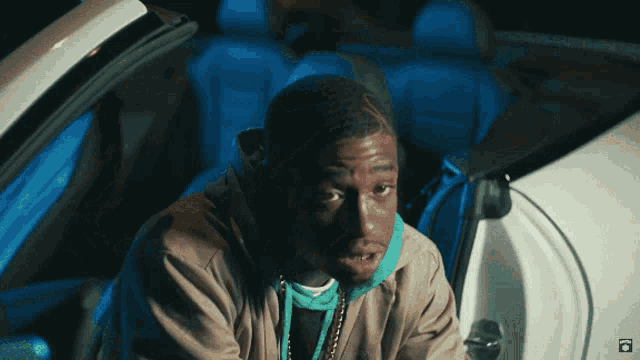 a man is sitting in the back of a car with a blue light on