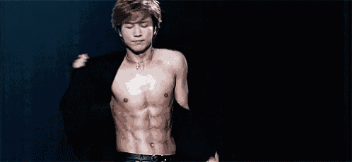 a shirtless man is standing on a stage with his arms outstretched and looking up .