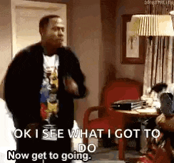 a man is dancing in a living room while a woman sits in a chair .