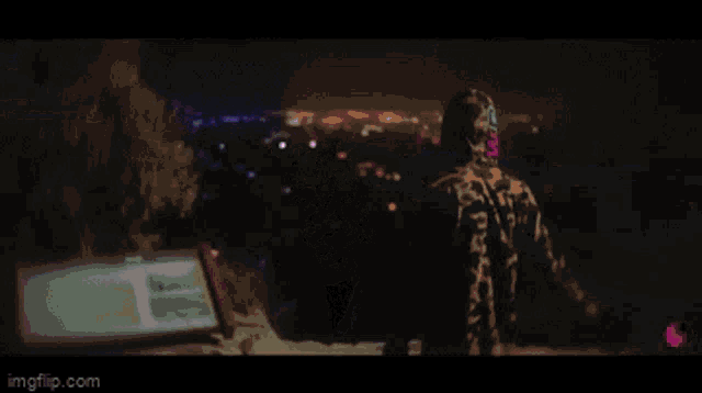 a man in a hoodie is standing in front of a purple light .
