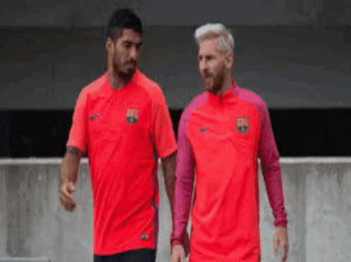 two soccer players wearing red shirts with the fcb logo on them