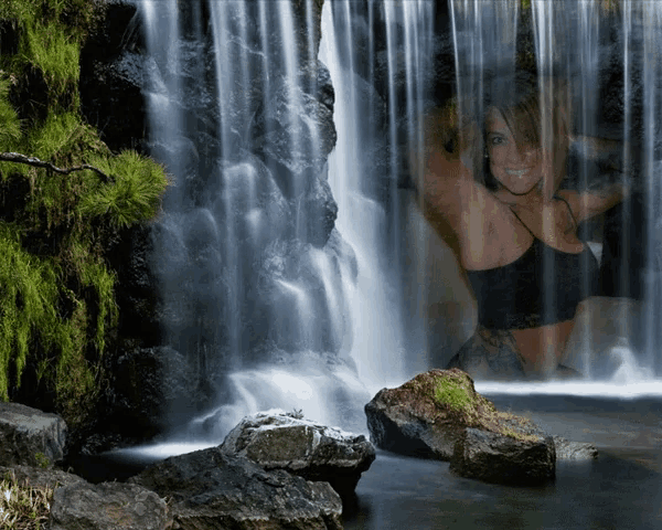 a waterfall with a woman in the background