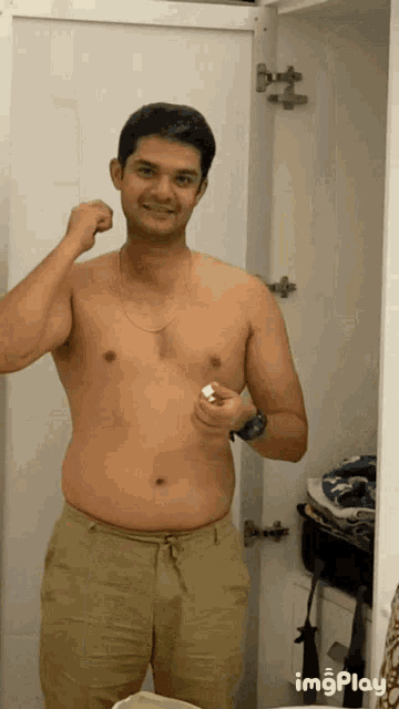 a shirtless man flexes his muscles in front of a closet with imgplay written on the bottom