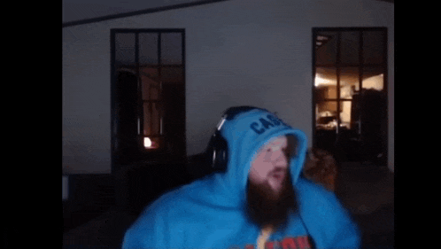 a man in a blue hoodie is smoking a cigarette .