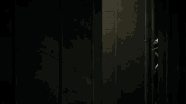 a man in a hat is peeking out of a doorway .