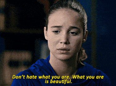 a woman in a blue shirt with the words " don t hate what you are what you are is beautiful "