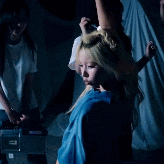 a woman in a blue shirt is dancing in front of a radio .