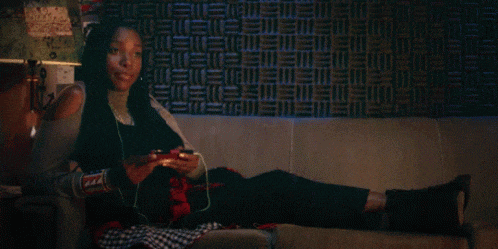 a woman is sitting on a couch with her legs crossed and listening to music
