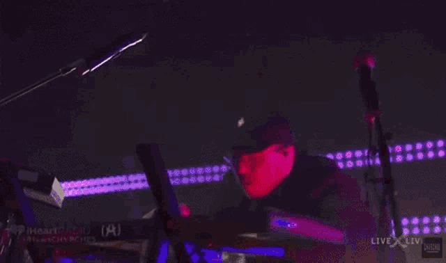 a man is playing a keyboard in front of a live x live logo