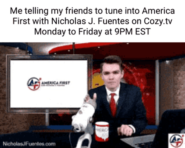 a man in a suit and tie is sitting in front of a screen that says " america first "