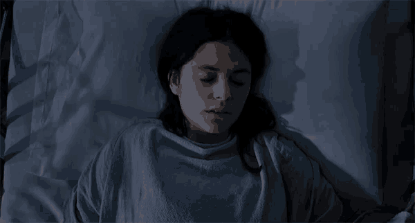 a woman is laying in a hospital bed with a needle in her arm
