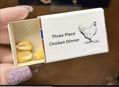three piece chicken dinner in a matchbox with corn