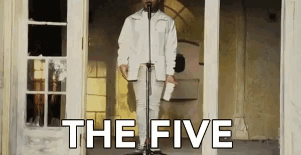 a man is standing in front of a microphone with the words the five written on the bottom .