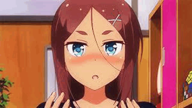 a close up of a girl with brown hair and blue eyes making a funny face .