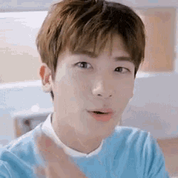 a young man wearing a blue sweater and a white shirt is making a funny face .