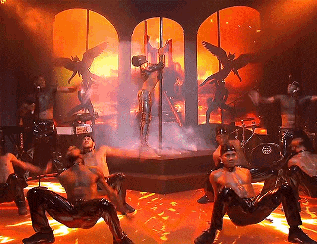 a group of men are dancing on a stage in front of a drum set that says yamaha on it