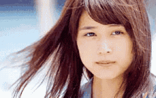 a close up of a young woman 's face with her hair blowing in the wind .