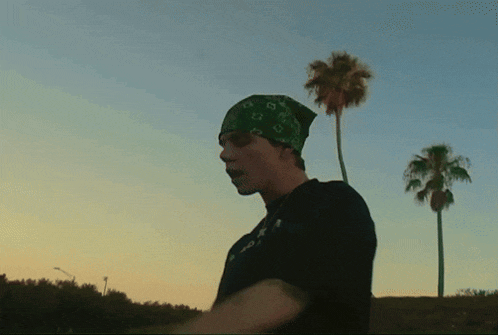 a man wearing a bandana and a t-shirt that says ' a ' on it