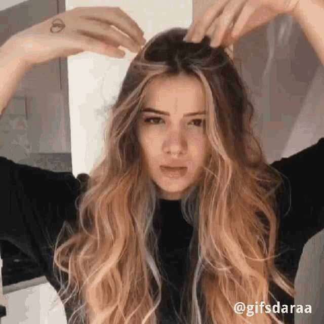a woman with long blonde hair has a tattoo on her arm