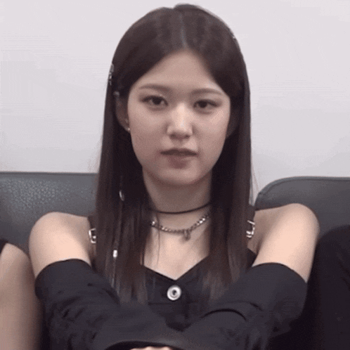 a woman wearing a choker necklace and black gloves