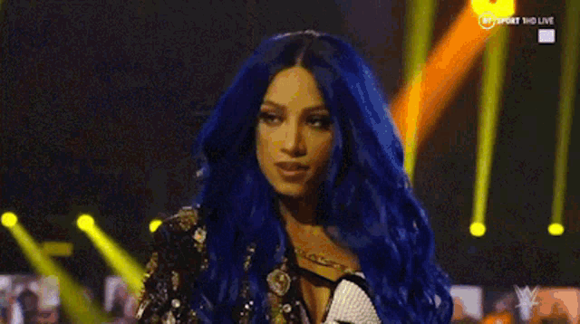 a woman with blue hair is standing in front of a yellow light .