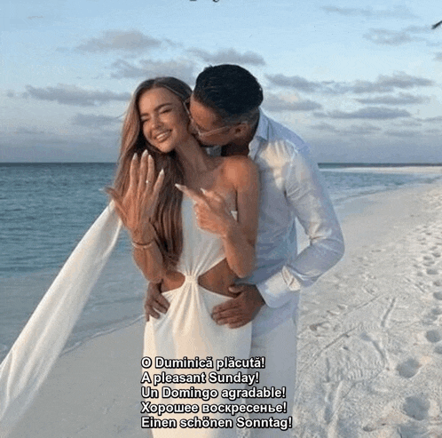 a man is kissing a woman on the cheek on the beach
