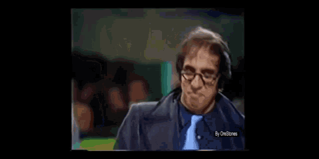 a man wearing headphones and a blue tie is making a funny face .