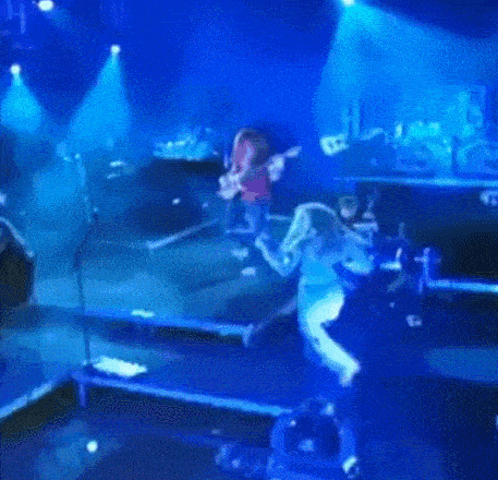 a group of people playing instruments on a stage in a dark room