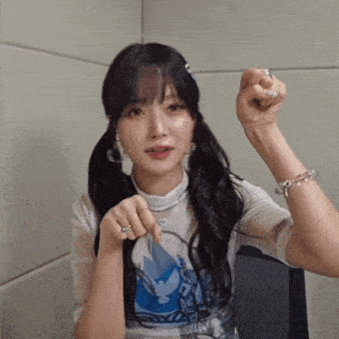 a woman with pigtails is wearing a bracelet and a ring